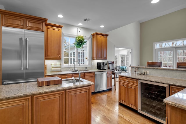 117 Morning Side Ter, East Stroudsburg, PA 18302 - kitchen featuring light stone counters, a sink, beverage cooler, backsplash, and appliances with stainless steel finishes