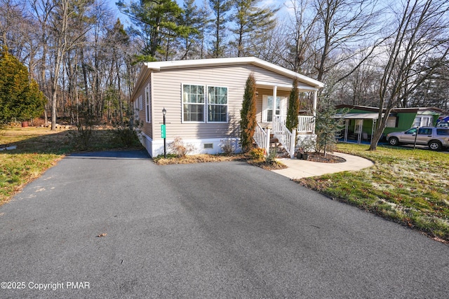 manufactured / mobile home with crawl space, covered porch, and aphalt driveway