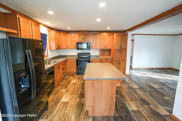 kitchen featuring black appliances, dark wood finished floors, a center island, and crown molding