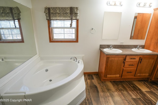 full bathroom featuring a bath, a healthy amount of sunlight, and a sink