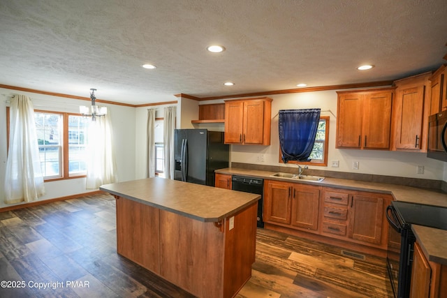 kitchen featuring black appliances, a sink, dark wood-style floors, a center island, and brown cabinetry