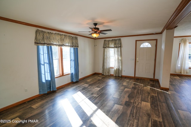 foyer entrance with crown molding, wood finished floors, and baseboards