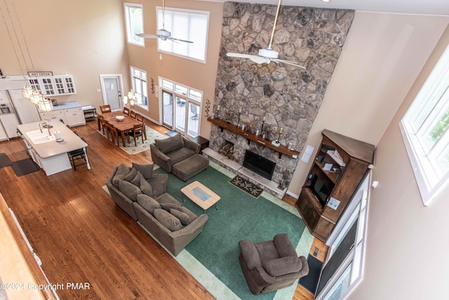 living room featuring a wealth of natural light, a ceiling fan, and wood finished floors