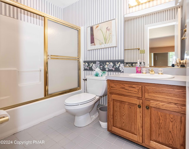 bathroom featuring vanity, enclosed tub / shower combo, wallpapered walls, tile patterned flooring, and toilet