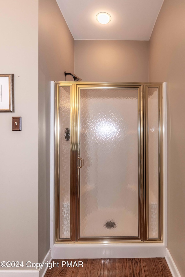 full bath featuring a shower stall and baseboards