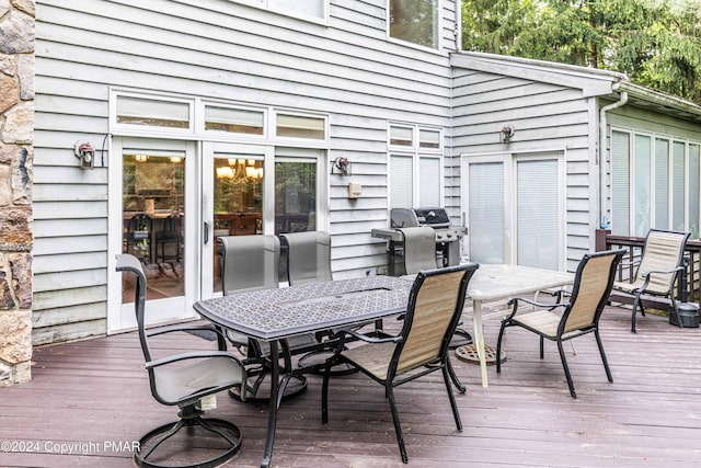 wooden deck featuring outdoor dining space and grilling area