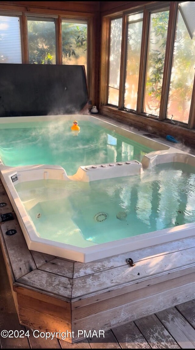 view of swimming pool with an indoor hot tub