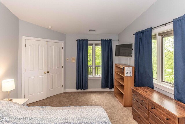 bedroom featuring lofted ceiling, carpet, a closet, and visible vents