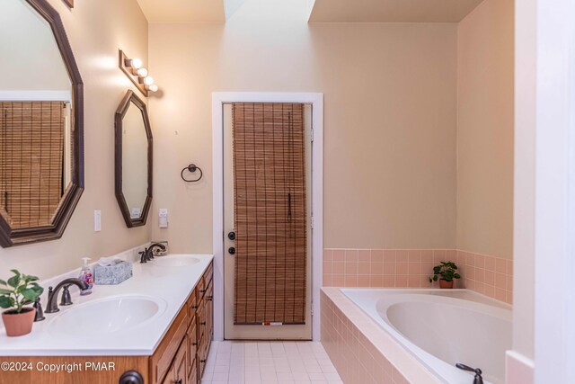 full bathroom with tile patterned flooring, double vanity, a bath, and a sink