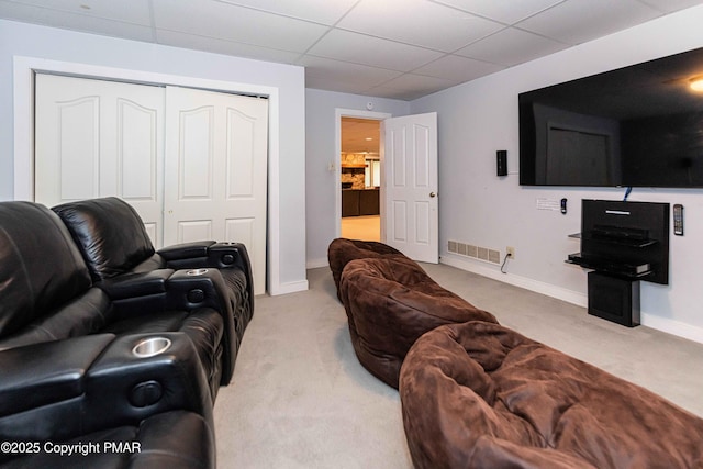 carpeted living room featuring baseboards, visible vents, and a drop ceiling