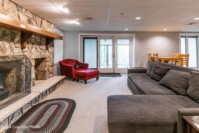 carpeted living area featuring visible vents, a fireplace, and a paneled ceiling