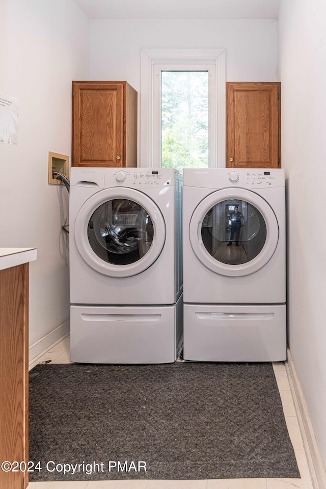 laundry area with baseboards, cabinet space, and independent washer and dryer