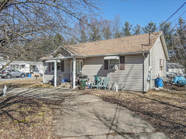 view of front of home with cooling unit and a shingled roof