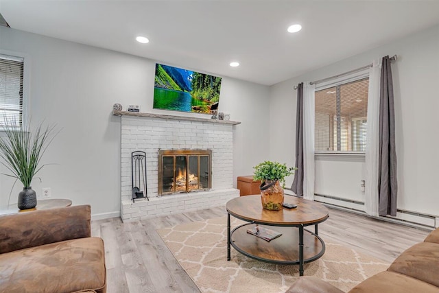 living area with wood finished floors, baseboards, recessed lighting, a baseboard heating unit, and a brick fireplace