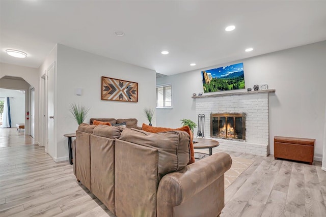 3509 Peak Dr, Tobyhanna, PA 18466 - living area featuring arched walkways, light wood-style flooring, recessed lighting, and a brick fireplace