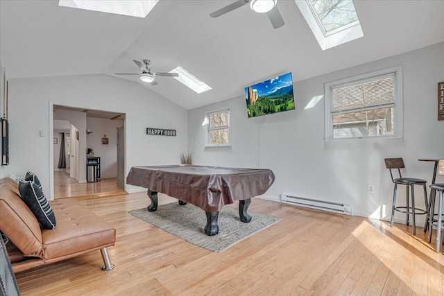 rec room with billiards, wood finished floors, vaulted ceiling with skylight, a baseboard radiator, and ceiling fan