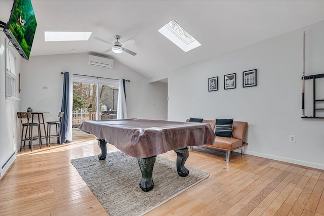 rec room with light wood-type flooring, a ceiling fan, a wall mounted AC, vaulted ceiling with skylight, and pool table