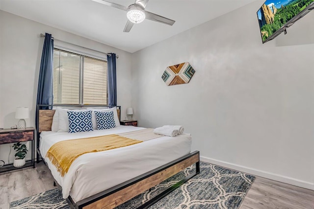 bedroom featuring a ceiling fan, wood finished floors, and baseboards