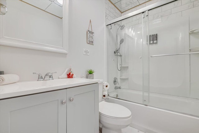 bathroom with vanity, toilet, and bath / shower combo with glass door