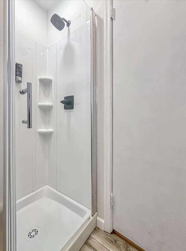 bathroom featuring a stall shower and wood finished floors