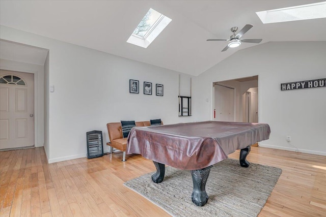 playroom with vaulted ceiling with skylight, baseboards, light wood-style floors, and ceiling fan