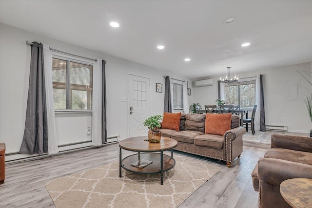 living room featuring light wood finished floors, a wall mounted AC, an inviting chandelier, and a baseboard radiator