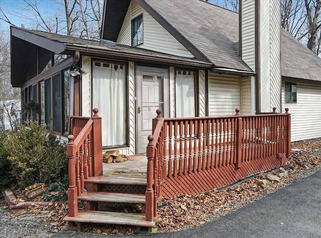 exterior space with roof with shingles and a chimney