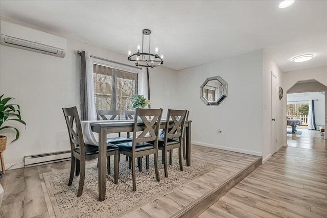 3509 Peak Dr, Tobyhanna, PA 18466 - dining space with a chandelier, light wood-style flooring, a wall unit AC, and a baseboard heating unit