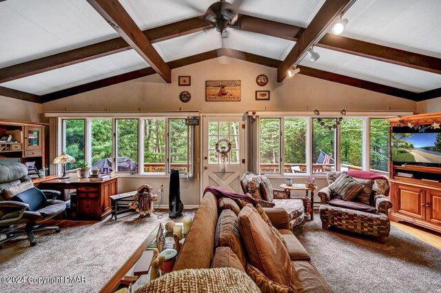 carpeted living room with ceiling fan, lofted ceiling with beams, and a healthy amount of sunlight