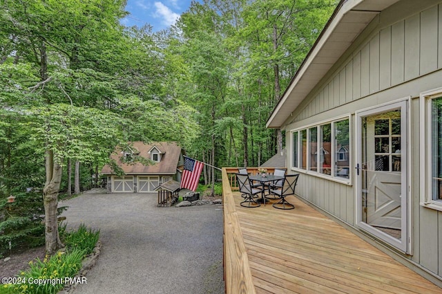 wooden deck featuring an outbuilding and a garage