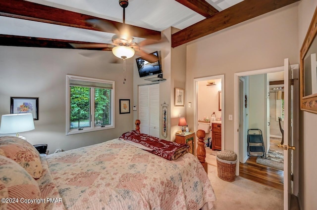 bedroom with ceiling fan, beam ceiling, and a closet