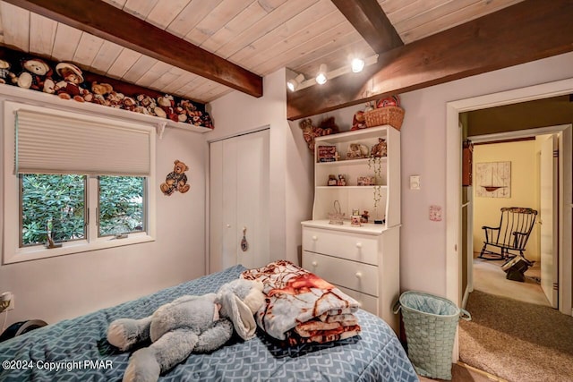 bedroom with wood ceiling, carpet flooring, beam ceiling, and a closet