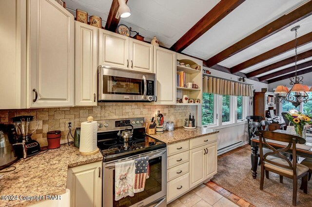 kitchen with tasteful backsplash, appliances with stainless steel finishes, light stone countertops, and a baseboard heating unit