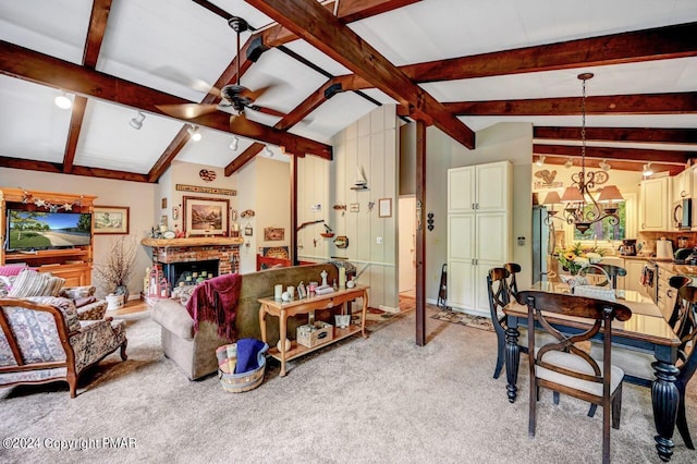 living room with lofted ceiling with beams, ceiling fan with notable chandelier, light colored carpet, and a fireplace