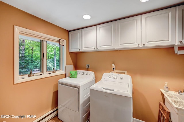 laundry room featuring separate washer and dryer, cabinets, and baseboard heating