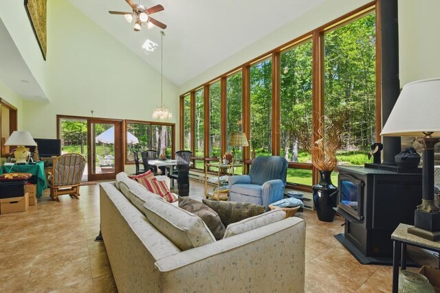 5153 Cresco Dr, Pocono Lake, PA 18347 - sunroom / solarium featuring a wood stove, healthy amount of natural light, high vaulted ceiling, tile patterned flooring, and a chandelier