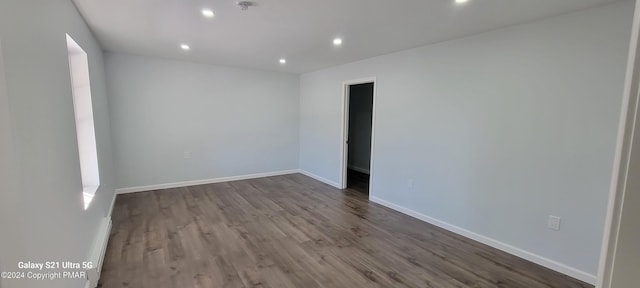 spare room featuring recessed lighting, dark wood finished floors, and baseboards