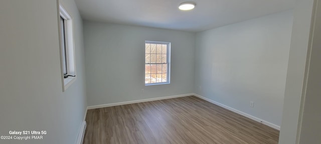 spare room featuring baseboards and wood finished floors