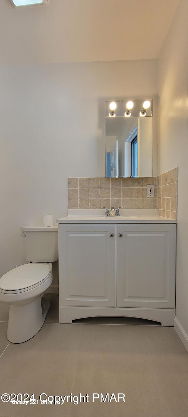 bathroom with backsplash, vanity, and toilet