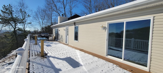 view of snowy exterior featuring a chimney