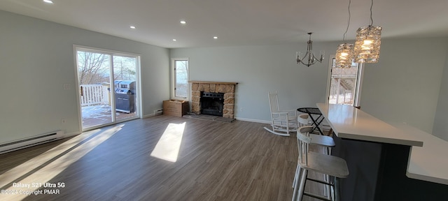 unfurnished living room featuring baseboards, a stone fireplace, wood finished floors, and recessed lighting