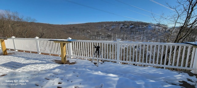 snow covered deck featuring fence