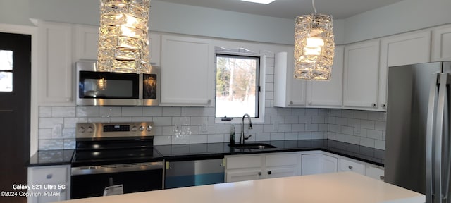 kitchen featuring appliances with stainless steel finishes, white cabinets, a sink, and backsplash