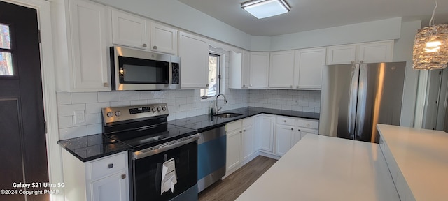 kitchen with stainless steel appliances, white cabinets, and a sink