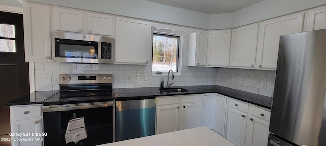 kitchen featuring white cabinetry, appliances with stainless steel finishes, backsplash, and a sink