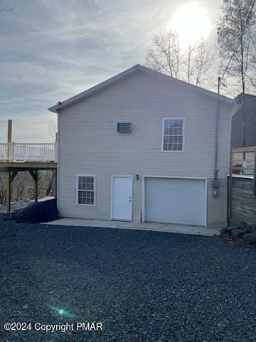 view of side of property featuring a wooden deck and an attached garage