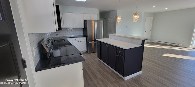 kitchen featuring dark wood-style floors, decorative backsplash, a baseboard heating unit, freestanding refrigerator, and a kitchen island