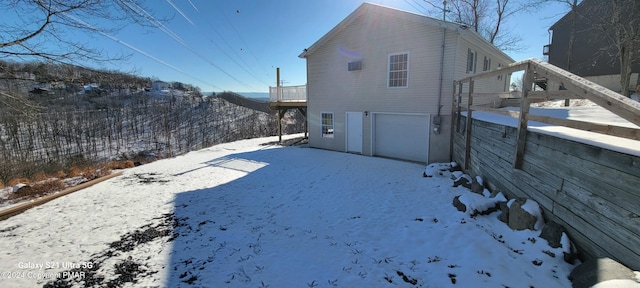 view of snow covered exterior with an attached garage