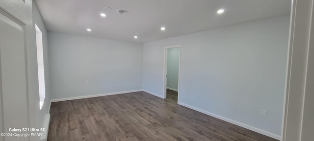 empty room featuring dark wood-style floors, recessed lighting, and baseboards