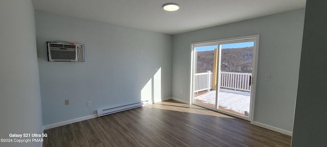 spare room featuring a baseboard radiator, an AC wall unit, baseboards, and wood finished floors